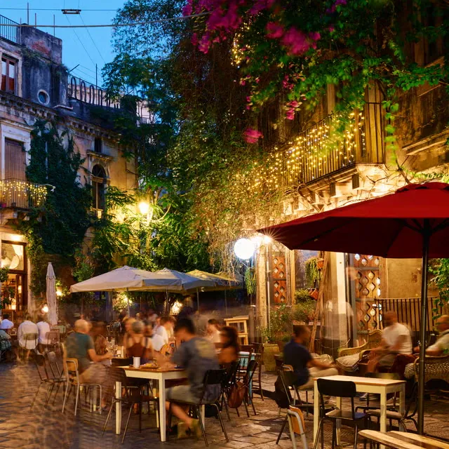 Tavoli all'aperto in una piazzetta, la sera