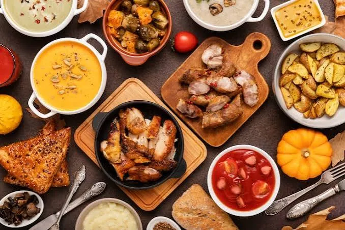 Tavola imbandita con zuppe, carne e patate
