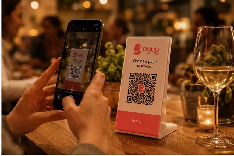Una persona inquadra con il telefono il QR di Byup sul tavolo di un ristorante